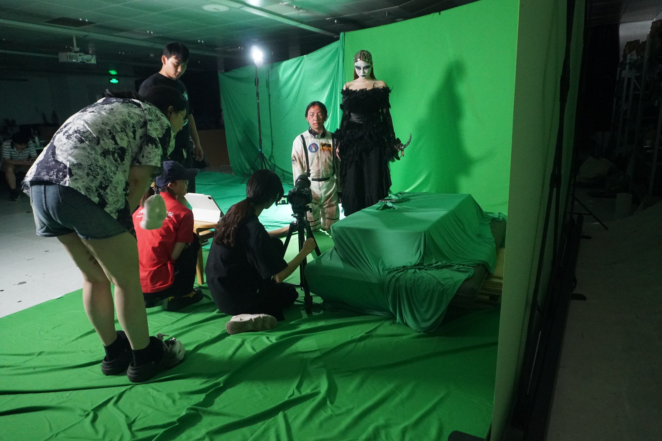 Students filming a final VFX project in a green-screen studio