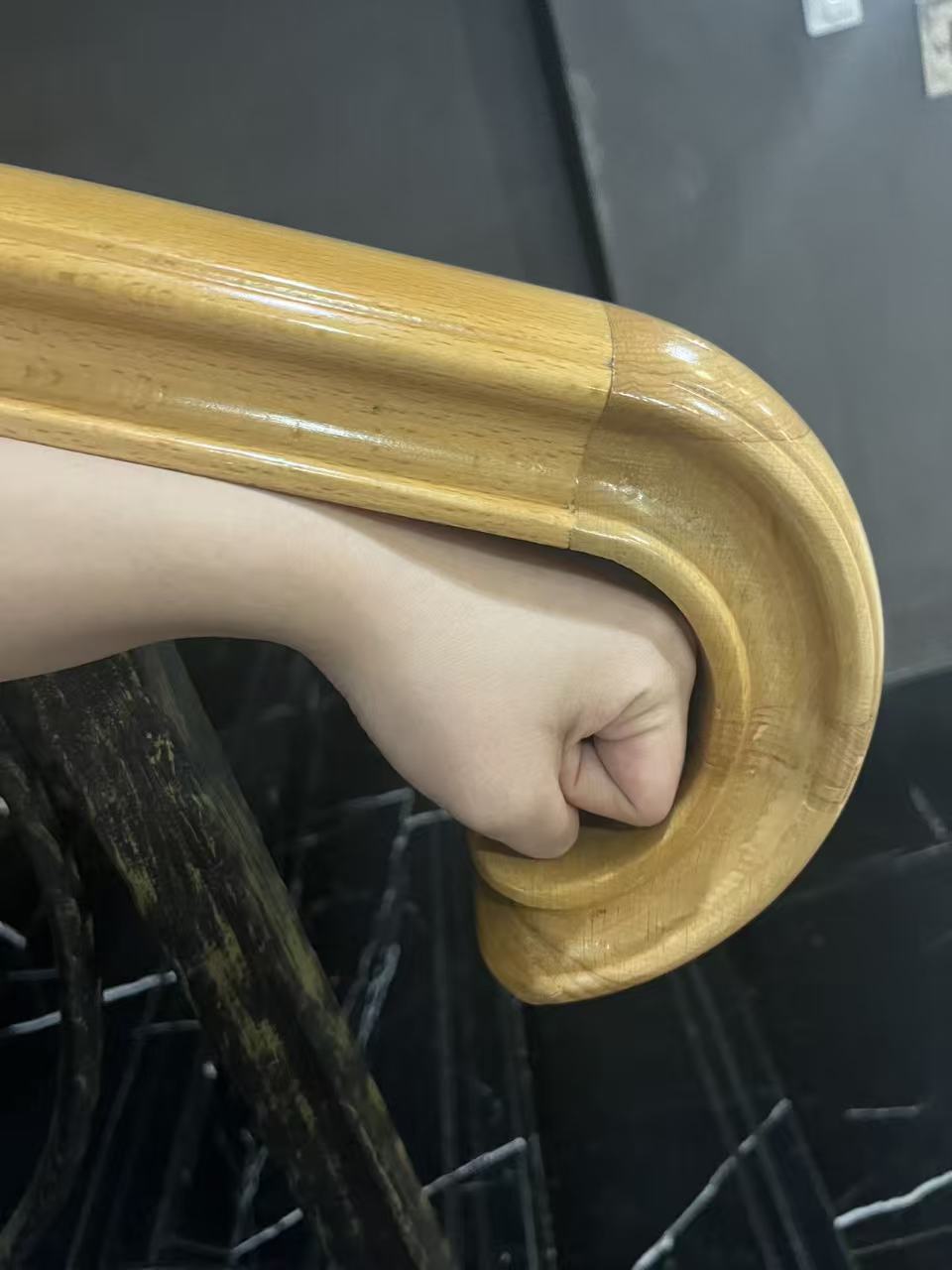 Hand following the curve of a railing